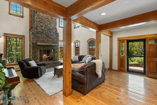 250 Silver Run Rd, Gallatin Gateway, MT 59730 - living room with beam ceiling, light wood-style flooring, a fireplace, healthy amount of natural light, and a baseboard heating unit