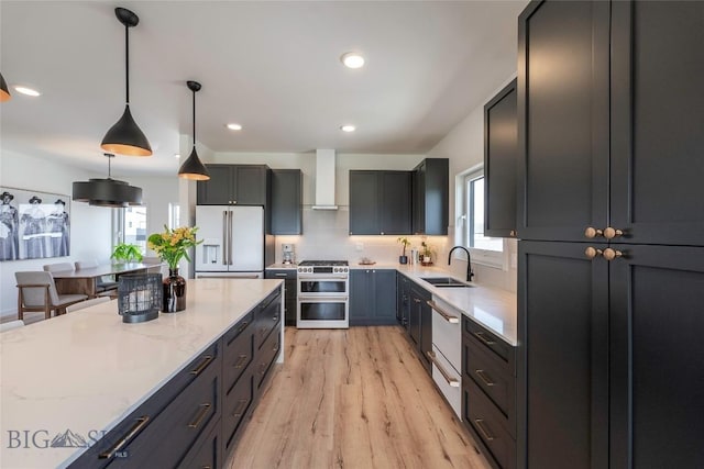 3083 S 27th Ave, Bozeman, MT 59718 - kitchen with high quality appliances, wall chimney range hood, plenty of natural light, light wood-type flooring, and recessed lighting