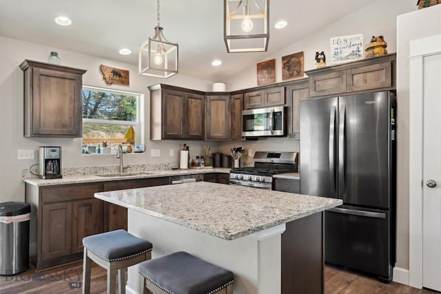 444 Highpark, Anaconda, MT 59711 - kitchen featuring appliances with stainless steel finishes, vaulted ceiling, dark wood-style flooring, a center island, and dark brown cabinets