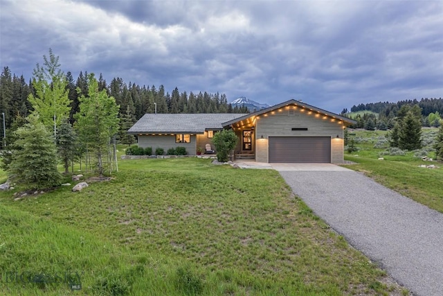 17 Chief Joseph Trl, Big Sky, MT 59716 - view of front facade with a garage, a front yard, driveway, and a forest view