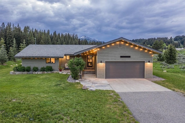 17 Chief Joseph Trl, Big Sky, MT 59716 - view of front of property with a garage, asphalt driveway, a front lawn, and a forest view