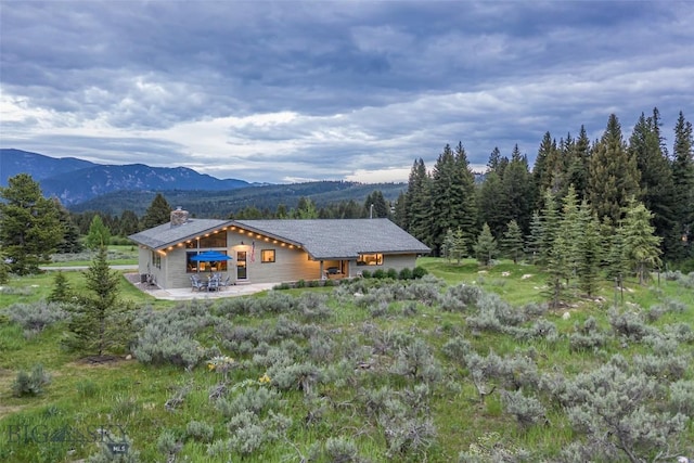 17 Chief Joseph Trl, Big Sky, MT 59716 - rear view of property with a chimney, a mountain view, and a patio area