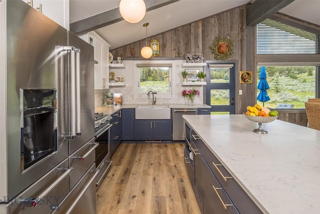 17 Chief Joseph Trl, Big Sky, MT 59716 - kitchen with appliances with stainless steel finishes, open shelves, light wood-style floors, decorative backsplash, and light stone counters