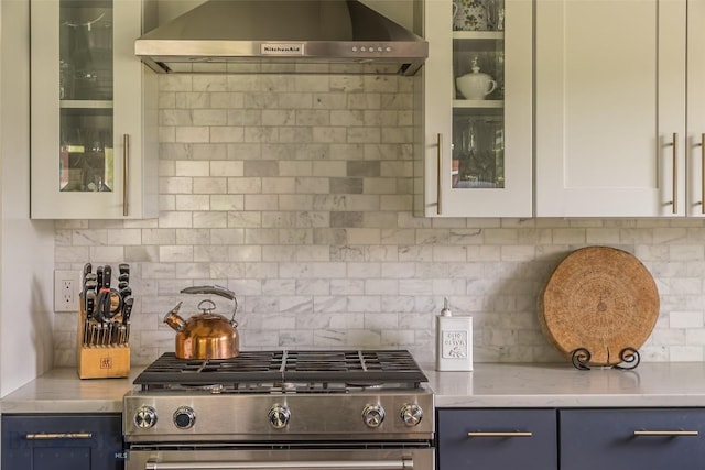 17 Chief Joseph Trl, Big Sky, MT 59716 - kitchen with stainless steel range with gas cooktop, ventilation hood, blue cabinets, decorative backsplash, and glass insert cabinets