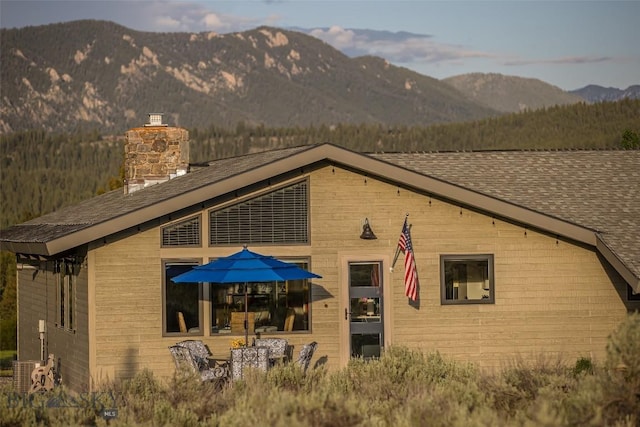 17 Chief Joseph Trl, Big Sky, MT 59716 - back of house with a mountain view, a chimney, and a shingled roof