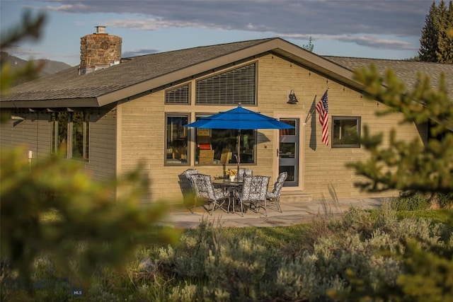 17 Chief Joseph Trl, Big Sky, MT 59716 - back of house with a chimney, a patio, and a shingled roof
