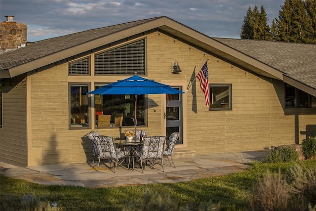 17 Chief Joseph Trl, Big Sky, MT 59716 - back of property with a shingled roof, a patio, and a chimney