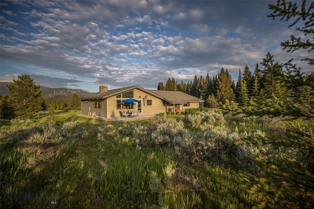17 Chief Joseph Trl, Big Sky, MT 59716 - rear view of house with a chimney and a patio area
