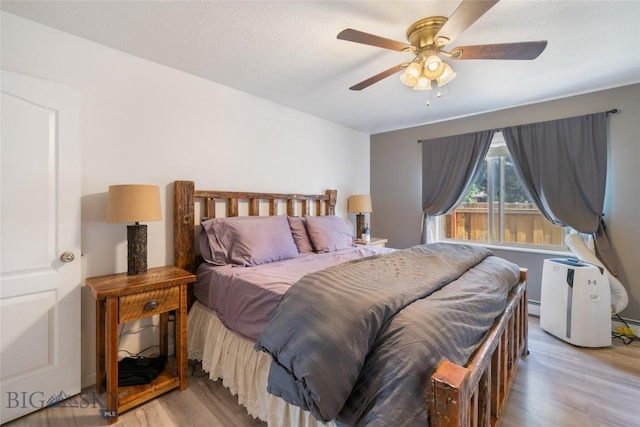 217 Lillian Way, Bozeman, MT 59718 - bedroom featuring wood finished floors, a baseboard radiator, and ceiling fan
