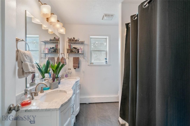 217 Lillian Way, Bozeman, MT 59718 - bathroom featuring double vanity, tile patterned flooring, and a baseboard heating unit