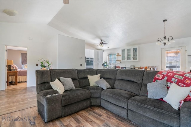 217 Lillian Way, Bozeman, MT 59718 - living room with vaulted ceiling, a chandelier, a ceiling fan, plenty of natural light, and light wood-style flooring
