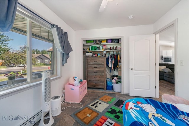 217 Lillian Way, Bozeman, MT 59718 - bedroom featuring a closet, a baseboard heating unit, ceiling fan, and stone finish floors