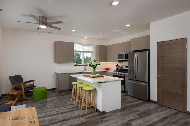223 New Ventures Dr, Bozeman, MT 59718 - kitchen featuring appliances with stainless steel finishes, a center island, a kitchen bar, dark wood finished floors, and a ceiling fan