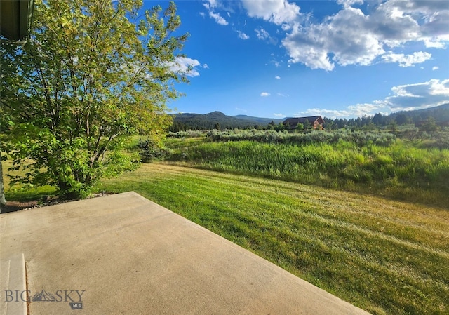 70 Candlelight Meadow Dr, Big Sky, MT 59716 - view of green lawn featuring a patio area and a mountain view