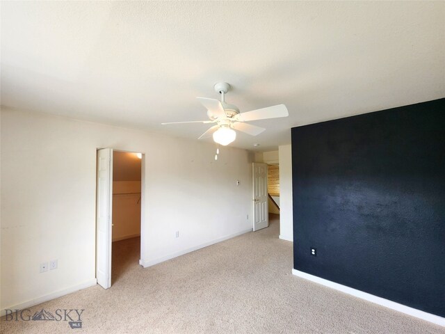 70 Candlelight Meadow Dr, Big Sky, MT 59716 - unfurnished bedroom featuring light carpet, a spacious closet, a ceiling fan, and a closet