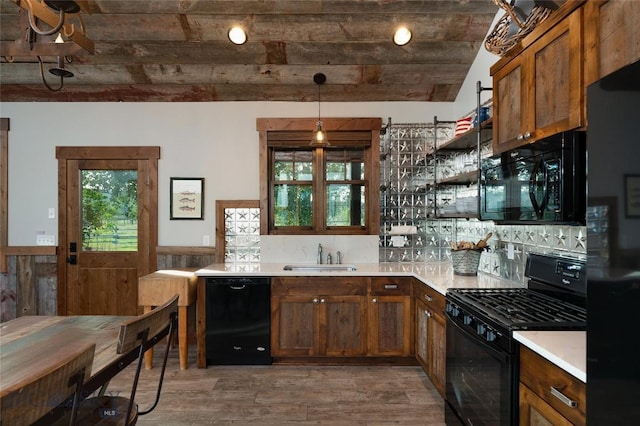 1400 Cottontail Rd, Gallatin Gateway, MT 59730 - kitchen with black appliances, wood finished floors, open shelves, light countertops, and brown cabinetry