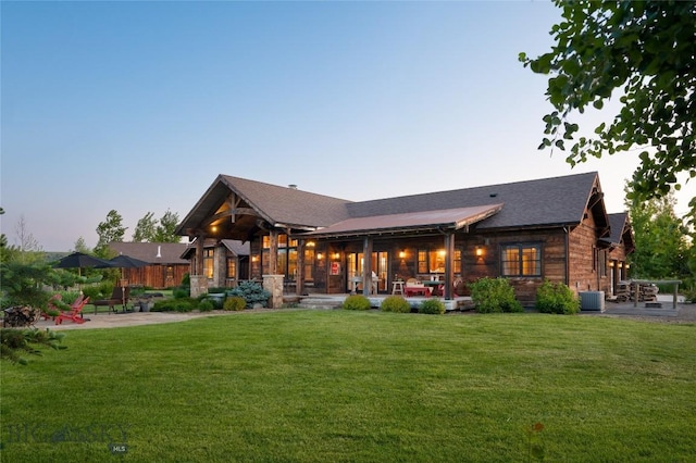 1400 Cottontail Rd, Gallatin Gateway, MT 59730 - back of property at dusk with a lawn and a patio