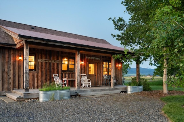 1400 Cottontail Rd, Gallatin Gateway, MT 59730 - property entrance with a porch, a metal roof, board and batten siding, and a mountain view