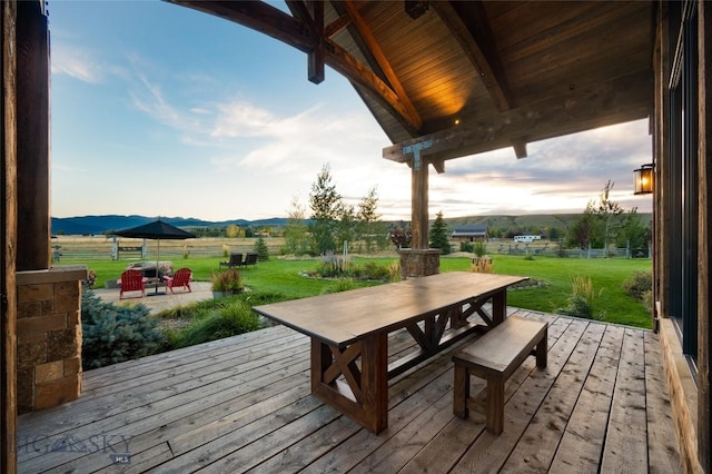1400 Cottontail Rd, Gallatin Gateway, MT 59730 - deck with outdoor dining area, a lawn, a mountain view, and a view of countryside