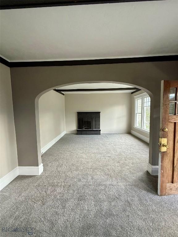 1717 Lowell, Butte, MT 59701 - unfurnished living room featuring carpet floors, arched walkways, and a fireplace