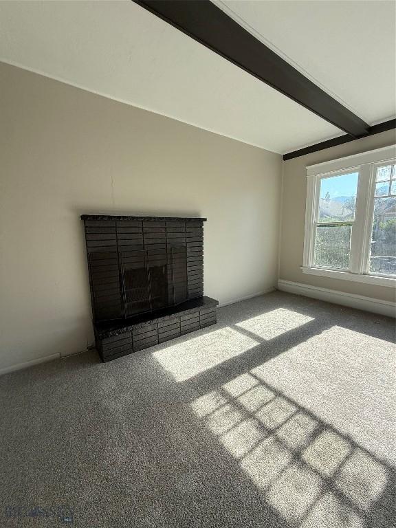 1717 Lowell, Butte, MT 59701 - unfurnished living room with carpet, a brick fireplace, and beam ceiling