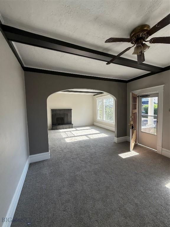 1717 Lowell, Butte, MT 59701 - unfurnished living room with arched walkways, carpet floors, ceiling fan, plenty of natural light, and beam ceiling
