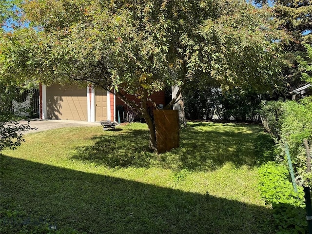 815 S 6th Ave, Bozeman, MT 59715 - view of green lawn featuring driveway and a garage