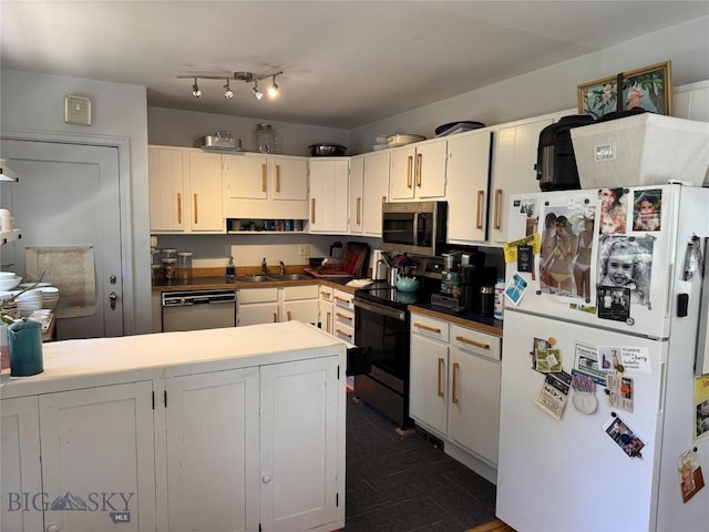 815 S 6th Ave, Bozeman, MT 59715 - kitchen featuring appliances with stainless steel finishes, a peninsula, white cabinets, and dark countertops