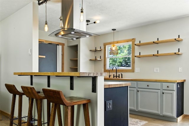 11 N Yellowstone Ave, Bozeman, MT 59718 - kitchen with open shelves, butcher block countertops, a breakfast bar area, and gray cabinetry