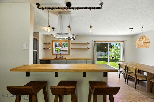 11 N Yellowstone Ave, Bozeman, MT 59718 - kitchen with wooden counters, a textured ceiling, a kitchen bar, and pendant lighting