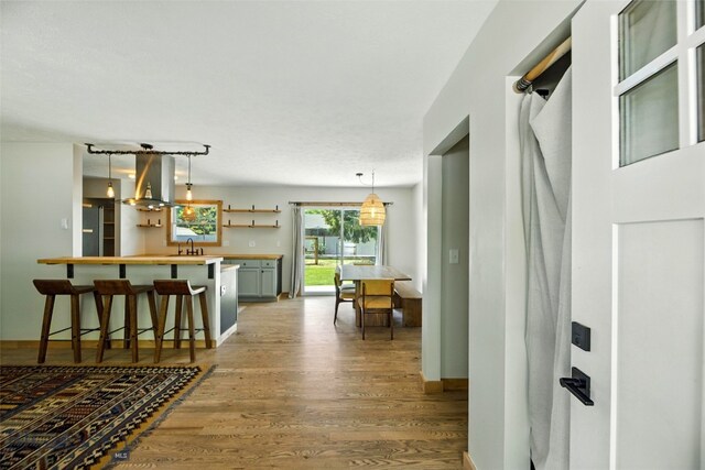 11 N Yellowstone Ave, Bozeman, MT 59718 - kitchen featuring extractor fan, light wood-style flooring, a breakfast bar area, decorative light fixtures, and light countertops