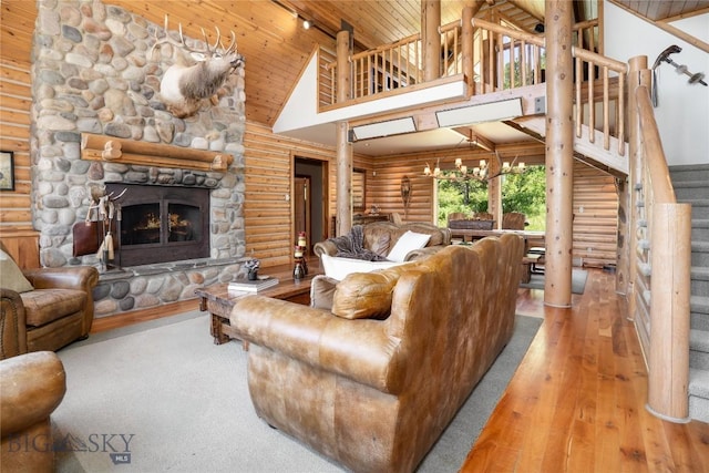 11540 Taiga Trl, Bozeman, MT 59715 - living area featuring rustic walls, high vaulted ceiling, wood ceiling, stairway, and a stone fireplace