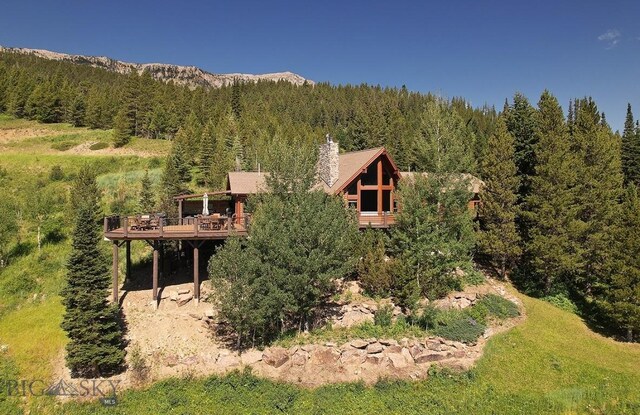 11540 Taiga Trl, Bozeman, MT 59715 - back of house with a wooded view and a wooden deck