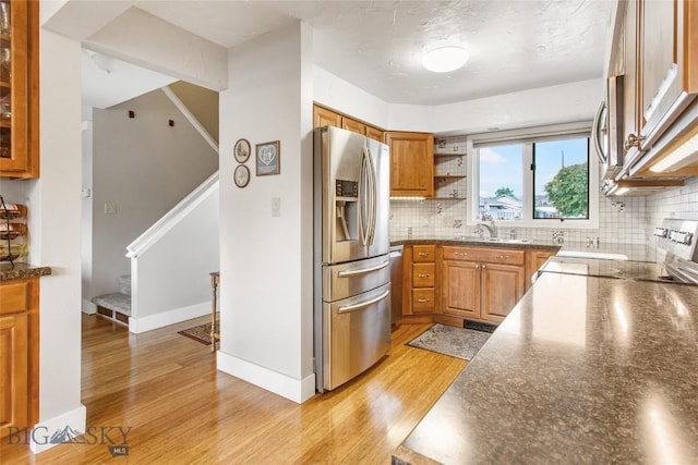 1406 Gilman Ave, Butte, MT 59701 - kitchen with stainless steel fridge with ice dispenser, range, brown cabinets, and light wood-type flooring
