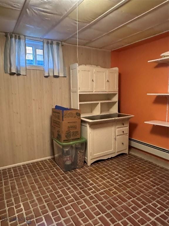 1914 Haggin, Anaconda, MT 59711 - below grade area featuring wooden walls, a baseboard radiator, and brick patterned flooring