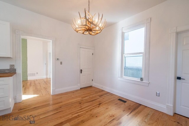 416 N 3rd St, Livingston, MT 59047 - unfurnished dining area featuring a chandelier and light wood-type flooring