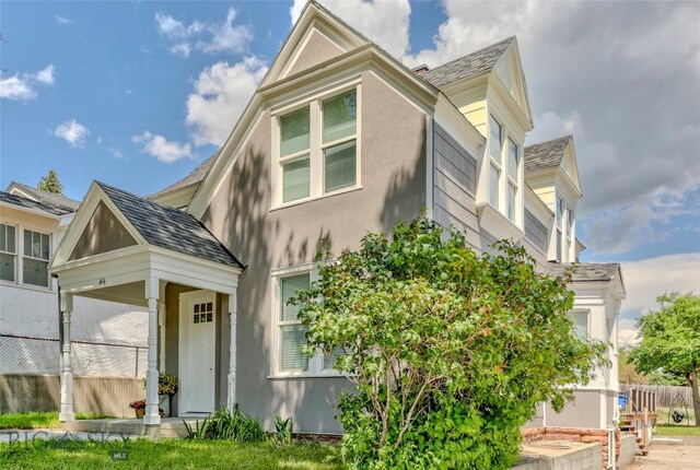 416 N 3rd St, Livingston, MT 59047 - view of front facade featuring stucco siding and roof with shingles