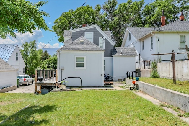 416 N 3rd St, Livingston, MT 59047 - rear view of house with a shingled roof and a chimney