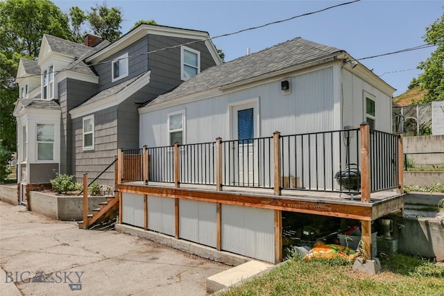 416 N 3rd St, Livingston, MT 59047 - rear view of house with roof with shingles and a deck