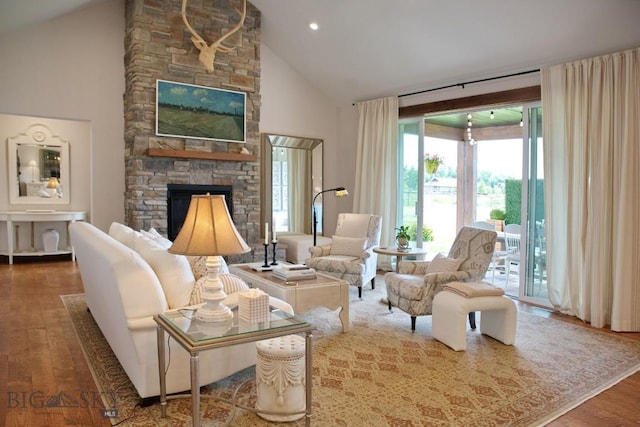 243 Tinkers Ln, Bozeman, MT 59718 - living room featuring a stone fireplace, wood finished floors, and high vaulted ceiling
