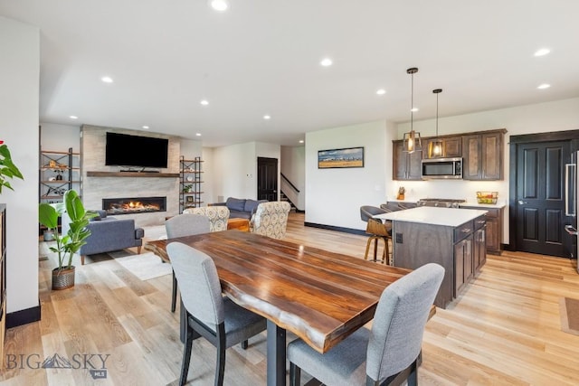 1484 Stewart Loop, Bozeman, MT 59718 - dining room featuring stairway, a large fireplace, light wood finished floors, and recessed lighting