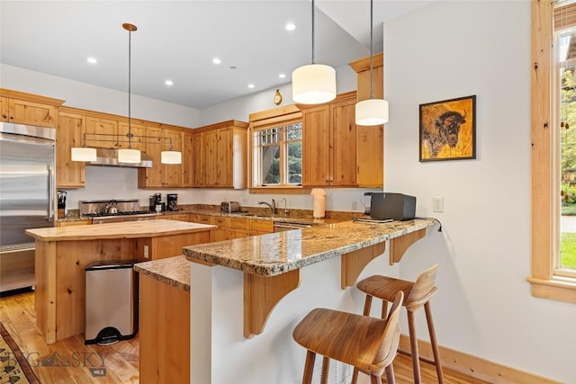 99 Pheasant Tail Ln Unit 1, Big Sky, MT 59716 - kitchen featuring built in refrigerator, under cabinet range hood, butcher block counters, a center island, and light wood finished floors