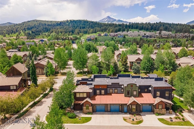 99 Pheasant Tail Ln Unit 1, Big Sky, MT 59716 - aerial view of residential area featuring a mountain backdrop and a heavily wooded area