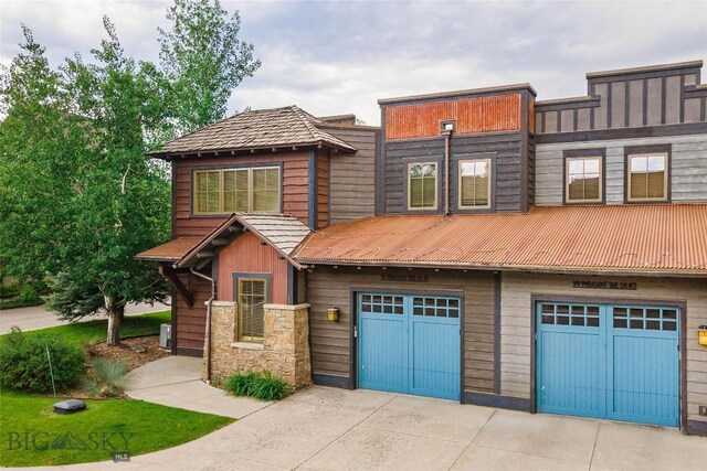 99 Pheasant Tail Ln Unit 1, Big Sky, MT 59716 - view of front of property with a garage, concrete driveway, and a metal roof