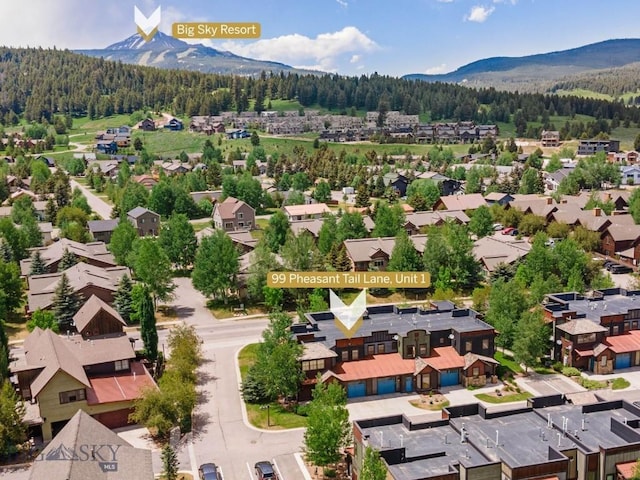 99 Pheasant Tail Ln Unit 1, Big Sky, MT 59716 - aerial perspective of suburban area with a heavily wooded area and a mountain backdrop