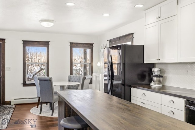 12977 Cottonwood Rd, Bozeman, MT 59718 - kitchen featuring black appliances, a baseboard heating unit, dark countertops, dark wood-style flooring, and white cabinetry