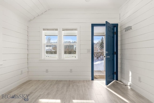 12977 Cottonwood Rd, Bozeman, MT 59718 - unfurnished room with light wood-type flooring, wooden walls, vaulted ceiling, and healthy amount of natural light