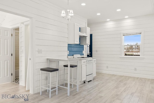 12977 Cottonwood Rd, Bozeman, MT 59718 - kitchen featuring white range oven, white cabinetry, light wood-style floors, recessed lighting, and a chandelier
