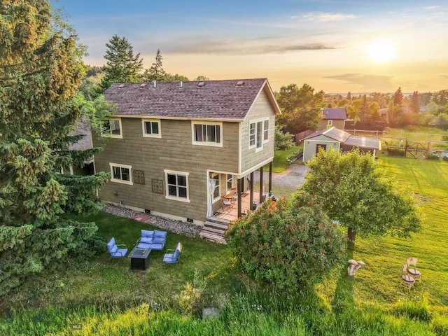 12977 Cottonwood Rd, Bozeman, MT 59718 - rear view of house featuring roof with shingles, an outdoor structure, and a lawn