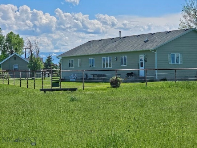 rear view of house featuring roof with shingles